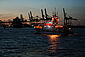Ein Bild von einem Seenotretterkreuzer in der Dämmerung in Front vor einem Hafen