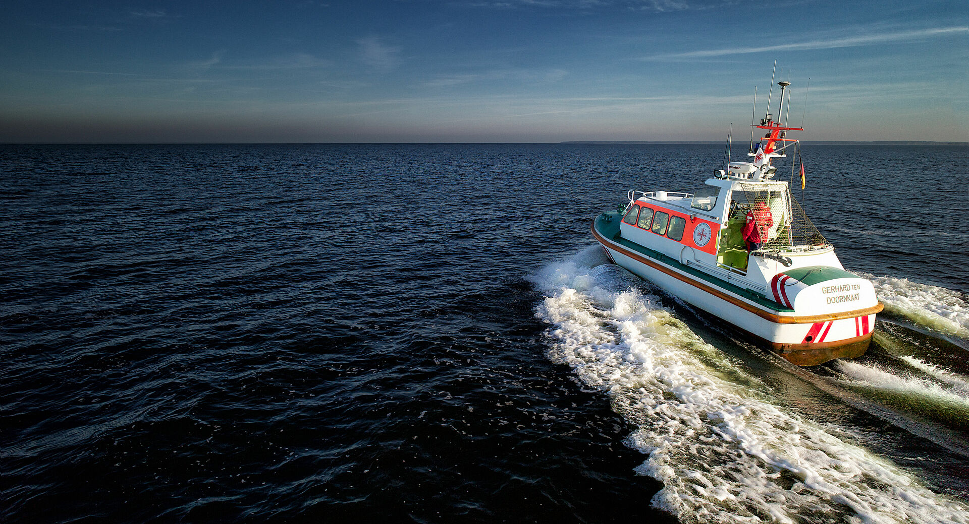 Das Seenotrettungsboot GERHARD TEN DOORNKAAT fährt bei gutem Wetter auf offener See Richtung Horizont.