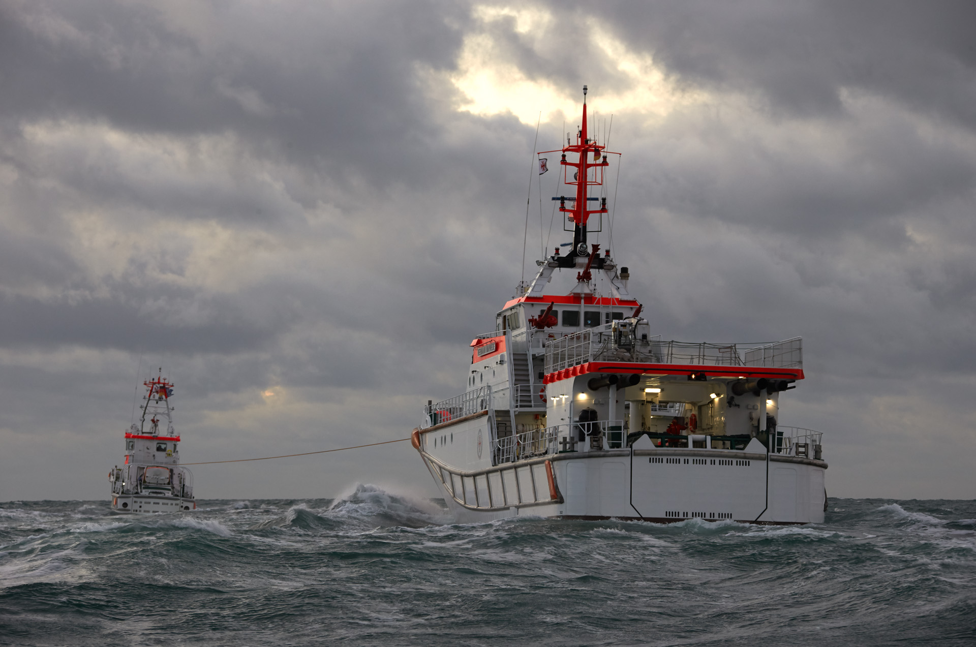 Ein Seenotrettungskreuzer schleppt einen anderen Seenotrettungskreuzer auf hoher See.