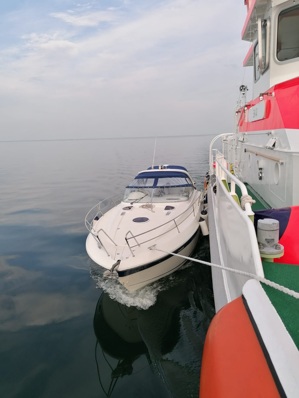 Ein Motorboot, das von einem Seenotrettungskreuzer geschleppt wird